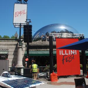 Chicago Cloud Gate sculpture (AKA The Bean) with Illini Fest event signs in the foreground